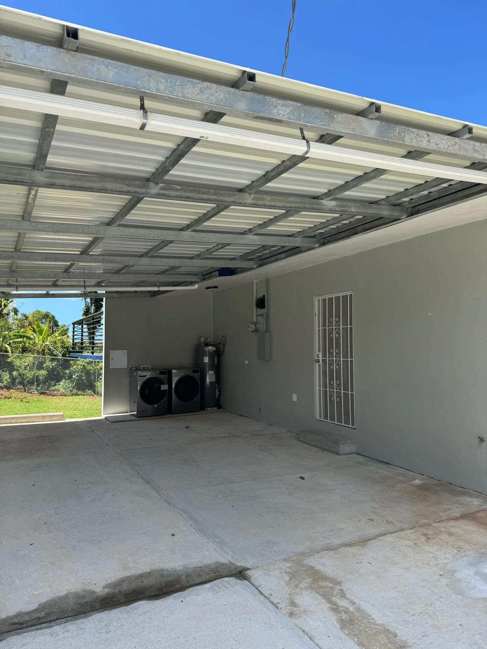 Finished carport with a steel purlin roof, painted wall, washer, dryer and water heater