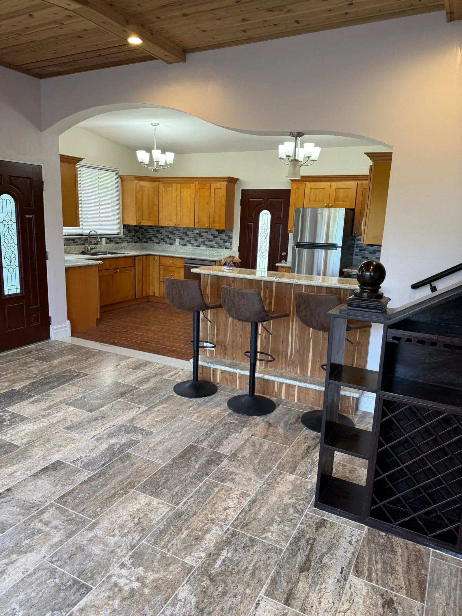The remodelled kitchen seen through a new arch, with a granite-topped cedar breakfast bar